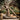 Statue of a Jesus Christ carrying a cross with 'Because of Love' text in a garden setting