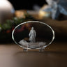 A clear oval crystal display plaque featuring an engraved or printed figure of Jesus walking on water standing on a base, photographed on a wooden surface with a softly blurred holiday background.