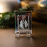 A clear acrylic or glass display block with an etched scene of God the Father and Jesus Christ under bare trees, standing above Joseph Smith on a wooden surface with a softly blurred indoor background.